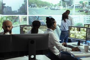 Indian operator following real time traffic footage from CCTV cameras, reporting any irregularities in the urban roads. Male employee monitoring drivers behavior and activity. photo