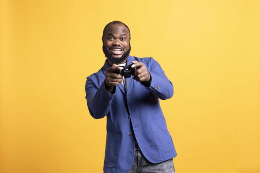Cheerful player happy after winning gaming console game, isolated over studio background. Joyful man satisfied after being victorious in videogame, defeating all enemies using gamepad photo