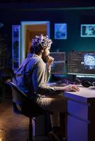 Man puts EEG headset on to transfer mind into computer virtual world, becoming one with AI superintelligence. Engineer using futuristic neuroscientific technology to transfer consciousness photo