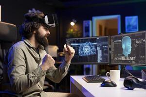 Computer engineer using VR headset, celebrating after awakening sentient AI asking existential questions. Cheerful programmer using virtual reality technology to interact with artificial intelligence photo