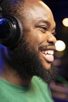 Enthusiastic sound engineer feeling joyful creating new music, doing what he loves in his home studio. Happy young producer smiling after hearing his finished track recorded and edited. Close up. photo
