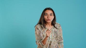 Upset indian person fighting with friend, doing scolding gesturing, isolated over studio backdrop. Annoyed woman arguing with opponent during discussion, doing admonishing hand gestures, camera A photo