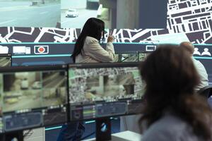Indian team leader instructs her staff to help couriers on field with gps coordinates of the shipment location, offering information on city routes by satellite map navigation. Order tracking. photo