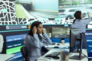 Indian call center operator gives updates on order tracking activity, handling delay complains from clients. Woman monitoring delivery trucks routes through traffic, gps satellite radar. photo