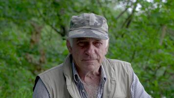 Portrait of middle-aged man. The old man is smiling and happy. In the background of green forest. video