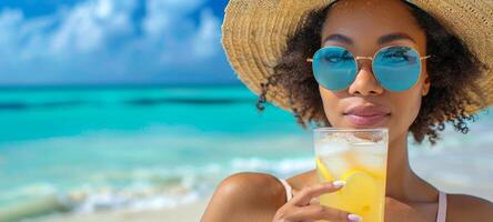 joven africano americano mujer disfrutando refrescante naranja bebida en un soleado playa. bañista con un verano cóctel. concepto de verano relajación, playa vacaciones, refrescante bebidas, y juvenil ocio foto