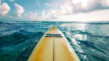Surfboard floating on clear turquoise ocean water with bright sky in backdrop. Surfing concept. Tropical getaway, summer vacation, aquatic sport adventure photo