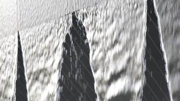 A waterfall with three peaks is shown in a blurry image. The water is falling from the top of the waterfall, creating a sense of movement and energy. The image evokes a feeling of awe. video