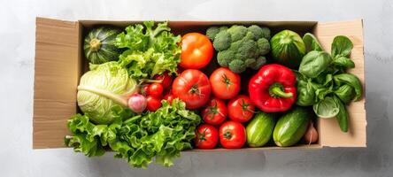 Assorted fresh vegetables in a cardboard box on a white textured background. Concept of healthy eating, organic food delivery, nutrition, fresh produce photo