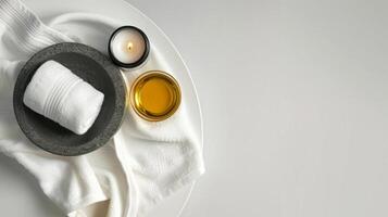 Spa essentials on a tray on a light textured background. Candles, towels, and essential oil set for relaxation. Concept of spa treatment, wellness. Banner. Copy space photo