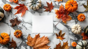 Elegant fall season mockup on marble. White blank card surrounded by autumn pumpkins and leaves. Concept of Thanksgiving invitation, harvest festival, October decor, and classy backdrop photo