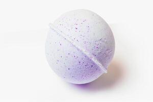 Fresh purple bath bomb presented on a pure white background. Simple and elegant spa accessory. Concept of cleanliness, self-care, tranquil spa experiences, wellness photo