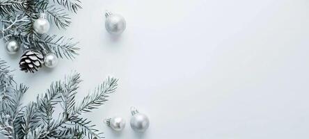 Sparkling silver Christmas ornaments with pine branches and pine cones on a white background. Concept of holiday decoration, festive season, winter celebration, Christmas design. Banner. Copy space photo