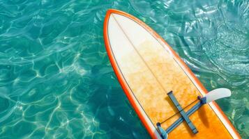 Surfboard on clear ocean water. Surfing equipment floating on serene sea. Concept of water sports, marine leisure, and ocean adventure. Banner. Copy space photo