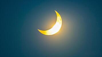 Dark sky with a bright crescent sun in a partial solar eclipse. Concept of solar eclipse, sky phenomenon, astronomy event, and natural spectacle photo