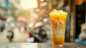 Traditional Thai iced tea in a tall glass, served chilled. Orange-colored tea with ice, in a cafe setting. Concept of refreshing beverages, Thai cuisine, summer drinks, Asian refreshment. Copy space photo