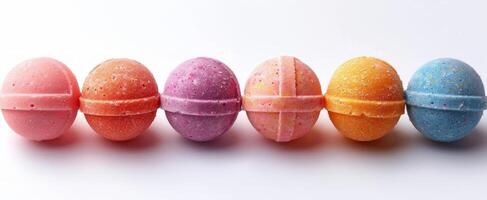 Colorful bath bombs arranged neatly on a white surface. Pastel bath bombs in a line showcasing variety. Concept of bath time luxury, wellness products, and clean design, isolated on a white background photo