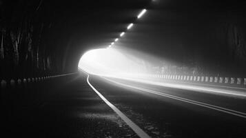 Black and white image of a railroad track inside a tunnel. Light at the end of the tunnel. Concept of journey, hope, direction, overcoming obstacles photo