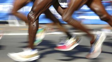 Blurred action shot of runners' legs in a marathon. African American Participants' shoes in a running race. Concept of athleticism, competition, speed, race events photo