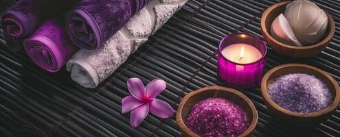 Decorative spa setting with purple towels and candles. Luxurious spa ambiance with floral elements. Concept of indulgence, tranquility, relaxation space, and elegant design. Copy space photo