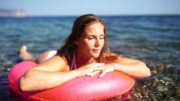 Sea Summer vacation happy woman floats on an inflatable donut mattress, pink swim ring. Summer travel holidays vacation on the sea. video