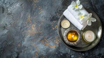 Spa essentials on a tray on a dark textured background. Candles, towels, and essential oil set for relaxation. Concept of spa treatment, wellness, and serene decor. Banner. Copy space photo