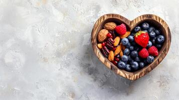 Heart-shaped wooden bowl filled with various healthy foods on a textured background. Raw vegetables, nuts, superfoods, greens concept. Banner. Copy space Foods that are good for a healthy heart photo