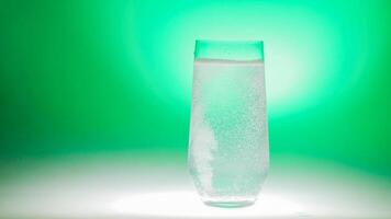 Effervescent water in a clear glass against a vibrant green backdrop, suggesting themes of refreshment, St Patricks Day celebrations, or healthy lifestyle concepts photo