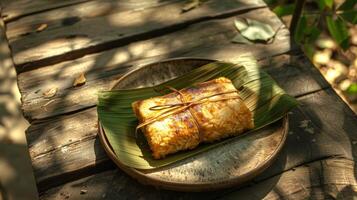 Thai banana in sticky rice, Khao Tom Mad, wrapped in banana leaves. Traditional Asian dessert on a plate. Concept of Thai desserts, natural packaging, sweet treats, photo