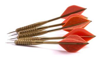 Golden darts with red flights isolated on a white background. Concept of leisure game, precision, sports hobby, fun activity photo
