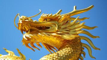 Golden dragon statue against a clear blue sky. Concept of mythology, cultural symbol, fantasy creature, majestic artwork photo
