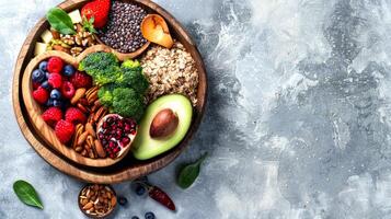 Heart-shaped wooden bowl filled with various healthy foods on a textured background. Raw vegetables, nuts, superfoods, greens concept. Banner. Copy space Foods that are good for a healthy heart photo