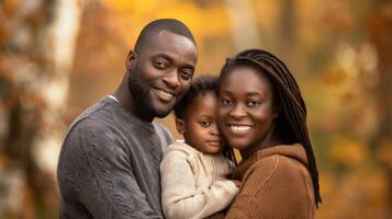 African American family in autumn park. Happy black parents and child in fall scenery. Concept of family bonding, nature, seasonal beauty photo