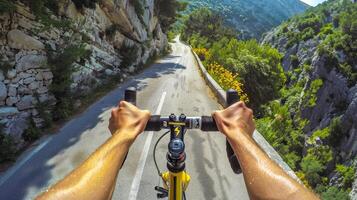 Cyclist riding on a mountain road. Hands grip the handlebars as the bike travels through scenic hills. Concept of adventure, cycling, outdoor activity, nature photo