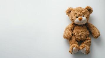 Plush brown toy bear sitting against a white background. Childhood companion. Concept of childhood, comfort, nostalgia, innocence. Copy space photo