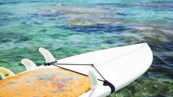 Surfboard on clear ocean water. Surfing equipment floating on serene sea. Concept of water sports, marine leisure, and ocean adventure. Banner. Space for text photo