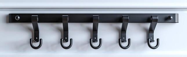Modern black wall-mounted coat hooks on white background. Concept of home organization, interior design, minimalism, functionality photo