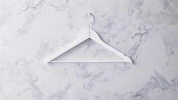 White coat hanger on a marble textured wall. Minimalist design. Concept of storage organization, home decor, simplicity, elegance photo