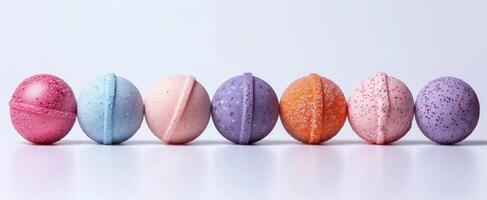 Row of colorful bath bombs lined up isolated on a white backdrop. Assorted bath bombs in pastel shades. Concept of spa, relaxation, bathing essentials, hygiene products. Banner. Space for text photo