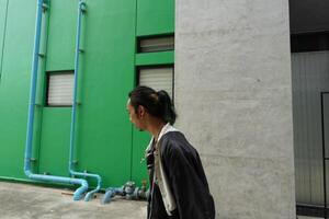 ASian man is dancing in hip hop style at outdoor space. Professional solo dancer is performing in public area. photo