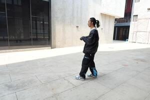 ASian man is dancing in hip hop style at outdoor space. Professional solo dancer is performing in public area. photo
