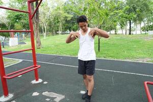 Asian man practicing gymnastics doing gymnastics bar and hoop exercises and stretching and resting for sports. photo