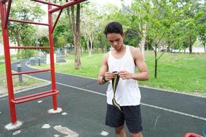 Asian man practicing gymnastics doing gymnastics bar and hoop exercises and stretching and resting for sports. photo