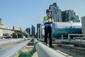 Urban rooftop scene showing a young engineer with a radio, inspecting and adjusting equipment in a sunny city environment. Safety and precision at work. photo