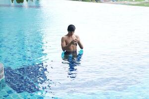 Asian men practicing swimming and preparing to play water polo and stretching and resting for water sports. photo