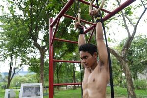Asian man practicing gymnastics, doing gymnastics bar and hoop exercises and stretching, resting for sports. photo