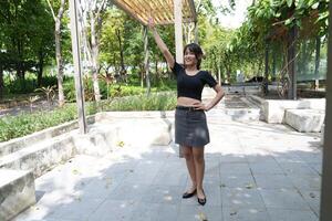 Asian woman dancing in the middle of a park photo