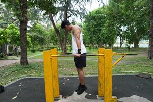 Asian man practicing gymnastics, doing gymnastics bar and hoop exercises and stretching, resting for sports. photo