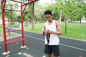 Asian man practicing gymnastics doing gymnastics bar and hoop exercises and stretching and resting for sports. photo
