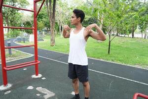 Asian man practicing gymnastics doing gymnastics bar and hoop exercises and stretching and resting for sports. photo